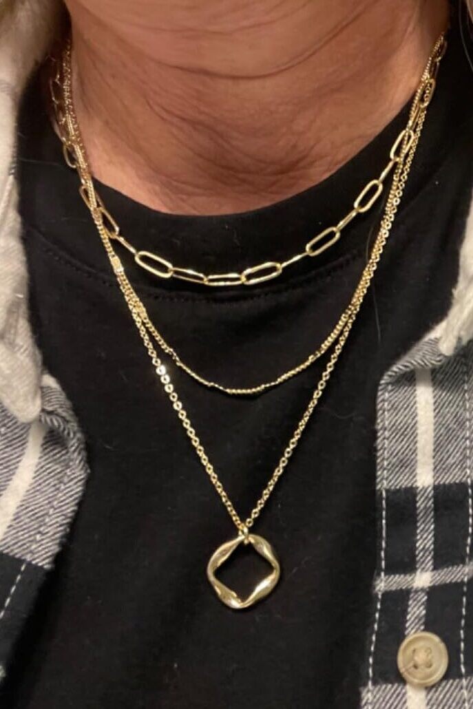 Customer wearing gold layered necklaces from Audrey & Roman