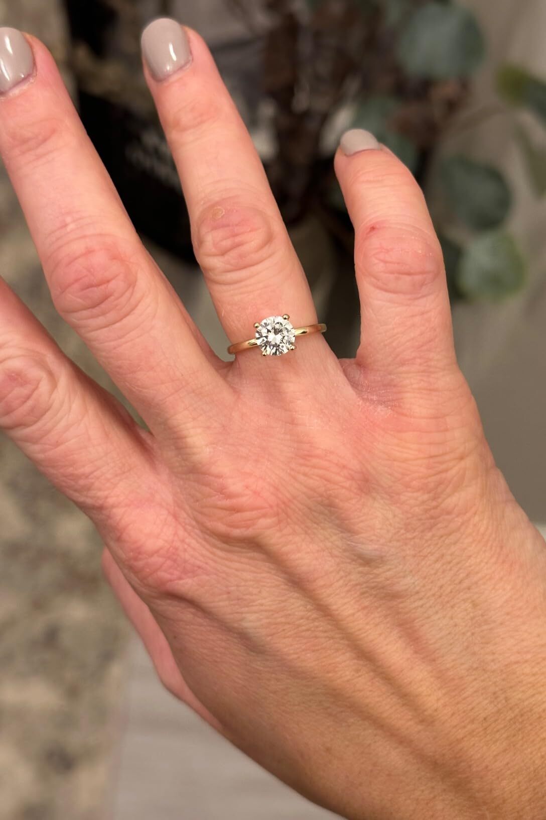 Customer wearing gold solitaire ring from Audrey & Roman